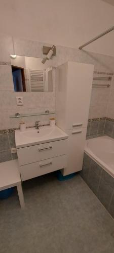 a white bathroom with a sink and a bath tub at Apartmán Jáchymov Krušné hory in Jáchymov