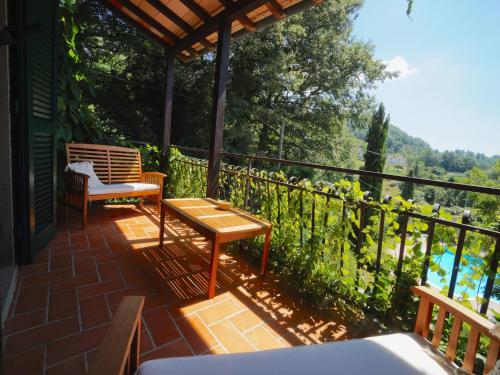 un patio avec deux chaises et une table sur un balcon dans l'établissement Villa Santa Fiora Farmhouse, à Santa Fiora
