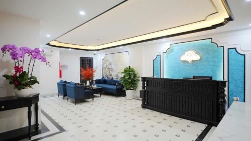 ein Wohnzimmer mit blauen Möbeln und lila Blumen in der Unterkunft Royal Hotel - Trinh Van Bo, Nam Tu Liem in Văn Trì