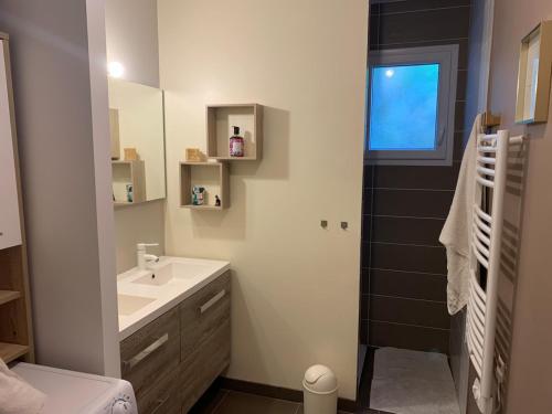 une salle de bain blanche avec lavabo et douche dans l'établissement Entre Coteaux et Dordogne, à La Celle-sous-Gouzon