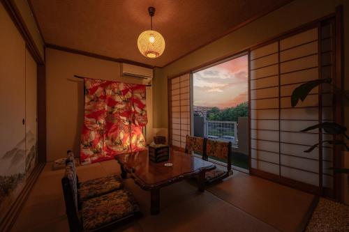 a living room with a table and a large window at kazane kamogawa風音鴨川 in Kyoto