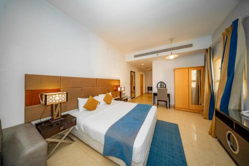 a bedroom with a large bed and a television at City Stay Grand Hotel Apartments - Al Barsha in Dubai