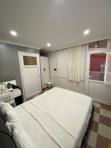 a bedroom with a large white bed and a window at Ezel Group Hotel in Antalya