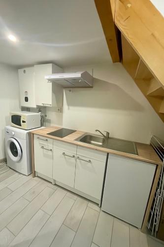 a kitchen with a sink and a washing machine at Charmant studio avec mezzanine - proche de Angoulême in Saint-Saturnin