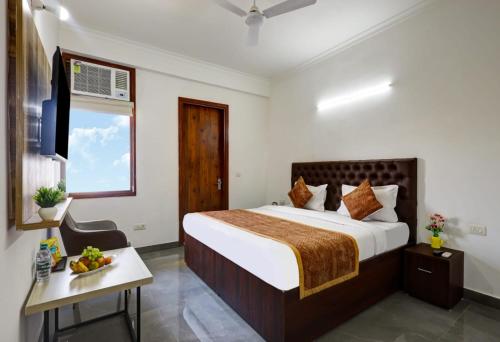 una stanza d'albergo con un letto e una finestra di Hotel La Corporate Suite a Noida