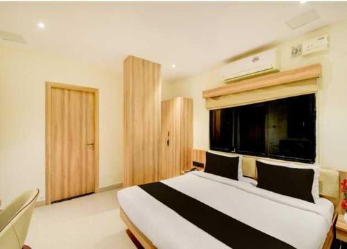 ein Schlafzimmer mit einem großen Bett mit einem großen Fenster in der Unterkunft Collection O Mangalpalli Temple Hyderabad Formerly Royal Grand in Ibrāhīmpatan