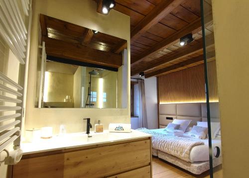 a bedroom with a bed and a sink and a mirror at AC Apartaments Tarter Chalet in El Tarter
