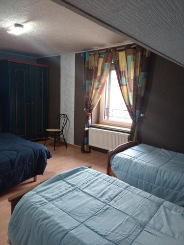 a bedroom with two beds and a window at gite chez Maise in Le Val-dʼAjol