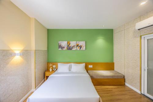 ホーチミン・シティにあるA25 Hotel - 142 Bùi Thị Xuânの緑の壁のベッドルーム1室(ベッド2台付)
