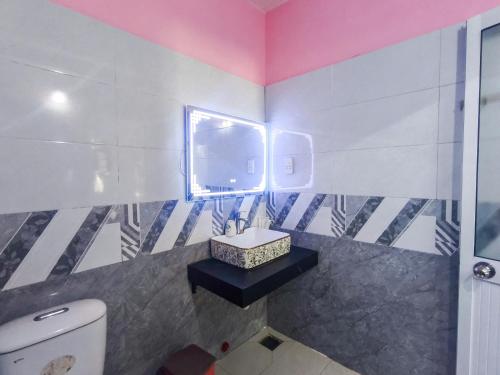 une salle de bain avec toilettes, lavabo et fenêtre dans l'établissement Nhà Nghỉ THẢO NGUYÊN XANH, à Buôn Ma Thuột