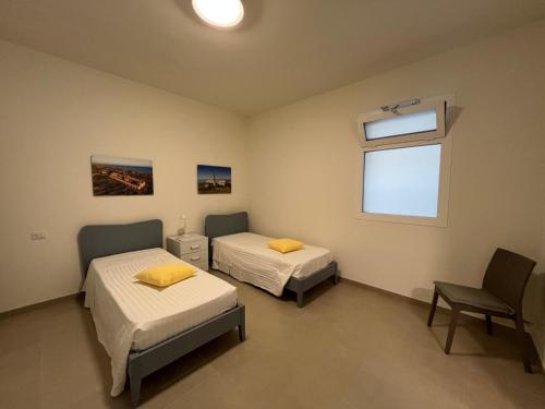 a hospital room with two beds and a window at IL GIARDINO DAMARE in Donnalucata