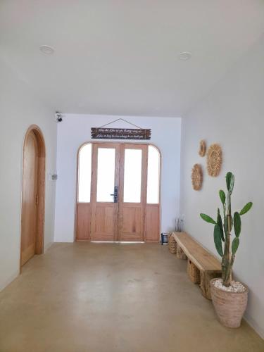 a room with a wooden door and a potted plant at Warm Way Beach Villas in Bình Sum