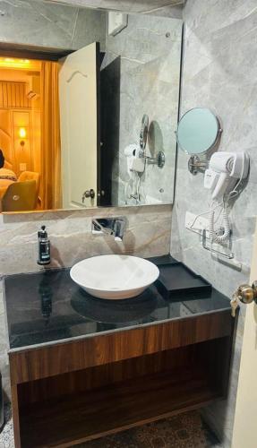 ein Badezimmer mit Waschbecken und Spiegel in der Unterkunft The Leon in Srinagar