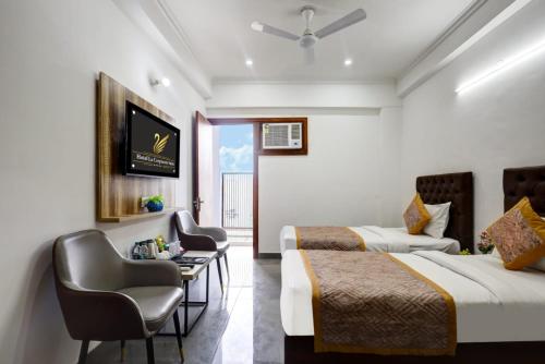 una camera d'albergo con due letti, un tavolo e delle sedie di Hotel La Corporate Suite a Noida