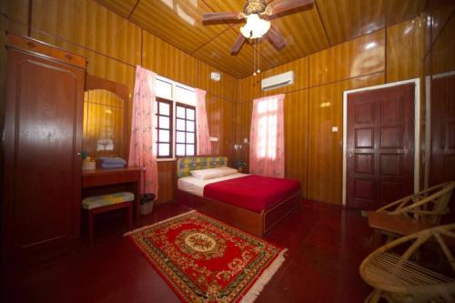 停泊島的住宿－Flora Bay 2酒店，一间卧室配有红色的床和吊扇