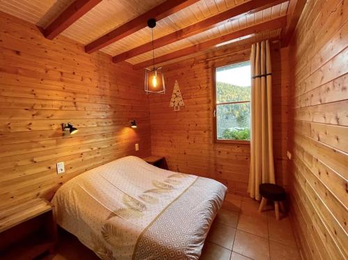 une chambre avec un lit dans une pièce en bois dans l'établissement Chalet au bord du lac Longemer, à La Celle-sous-Gouzon