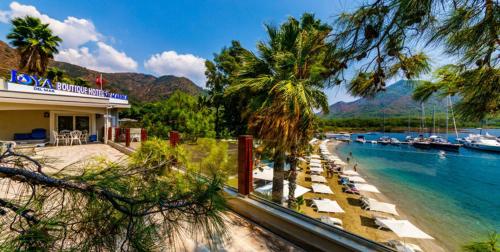 una playa con tumbonas y barcos en el agua en Joya Del Mar Hotel, en Marmaris