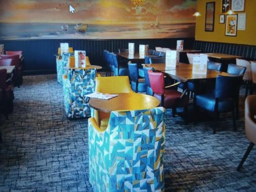a restaurant with tables and chairs in a room at Warm and Cosy, Torbay Waterside Holiday Home in Paignton