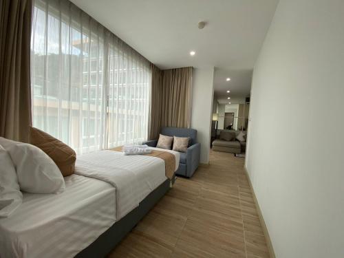 una camera da letto con un letto e una grande finestra di The Bay cliff By Tris a Patong Beach