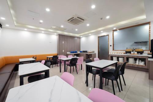 a restaurant with tables and chairs and a chalkboard at Hanting Premium Hotel Shanghai Pudong Airport Chenyang Road in Shanghai