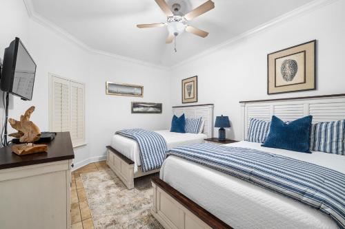 a bedroom with two beds and a flat screen tv at The Oasis at Orange Beach 2208 (Phoenix West II) in Orange Beach