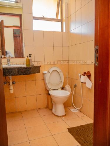 a bathroom with a toilet and a sink and a mirror at AfroHaki Homes in Mombasa