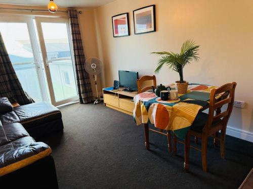 ein Wohnzimmer mit Tisch und Couch und ein Zimmer in der Unterkunft Newly Decorated Studio Apartment -City Centre- Sleeps 2 in Exeter