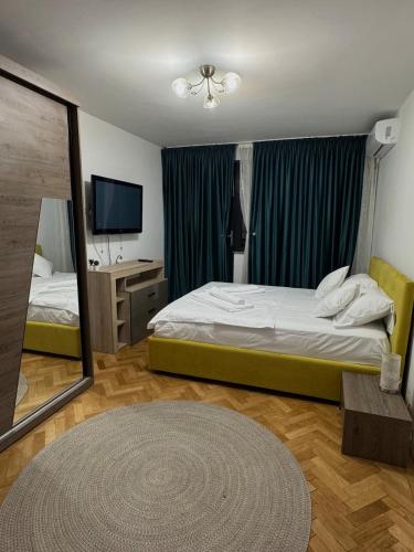 a bedroom with a bed and a mirror and a television at Central Apartment KM 0 in Craiova