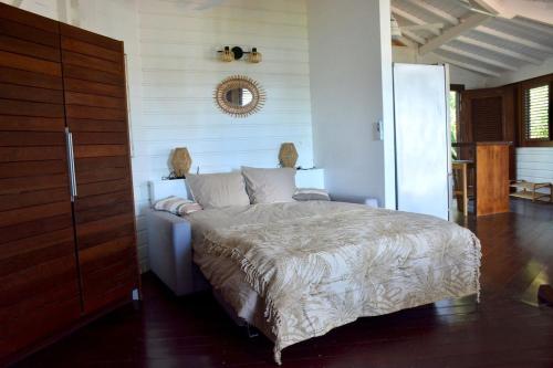 une chambre avec un lit et un miroir au mur dans l'établissement Casa Alba - 1 bedroom house - sea view, garden & swimming pool, à Oyster Pond