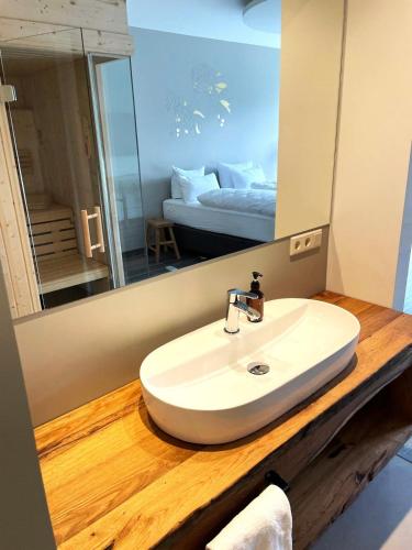 a bathroom with a sink and a mirror and a bed at Hotel Schloss Rattey in Schönbeck