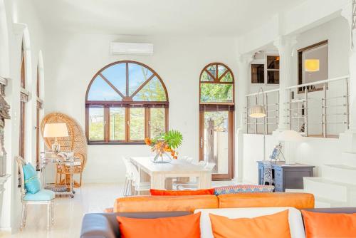 ein Wohnzimmer mit orangefarbenen Sofas und einem Tisch in der Unterkunft Jamanota Villa 4BR Mansion with Infinity Pool in Noord