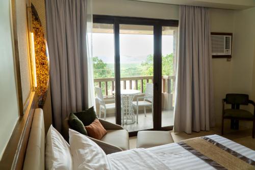 ein Hotelzimmer mit Bett und Balkon in der Unterkunft Coron Westown Resort in Coron