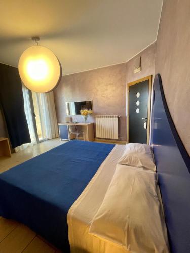 una camera da letto con un letto grande con una coperta blu di Apparthotel Angela ad Alezio