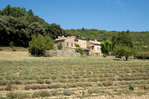Ein altes Haus mitten auf einem Feld in der Unterkunft Mas XVIIIème au cœur de la Drôme provençale in Béconne