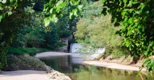 a river with a bridge in the distance at Casa mémé in Marco de Canavezes