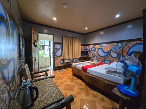 a bedroom with a bed with a fan in it at Islandfront El Nido in El Nido