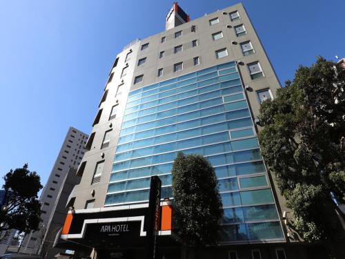 a tall building with glass windows on a city street at APA Hotel Chibachuo Ekimae in Chiba