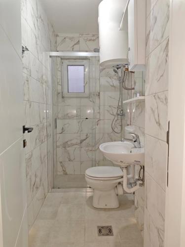 a bathroom with a toilet and a sink and a shower at Guest House Violet in Bečići