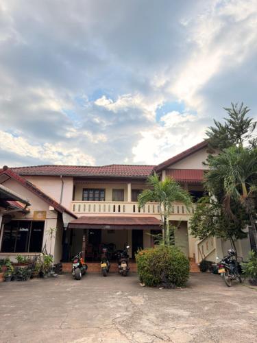 un gruppo di motociclette parcheggiate davanti a un edificio di Singxay guesthouse ເຮືອນພັກສິງໄຊ 