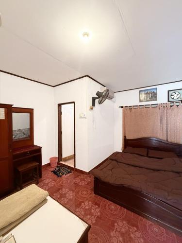 una stanza con un letto, un tavolo e uno specchio di Singxay guesthouse ເຮືອນພັກສິງໄຊ 