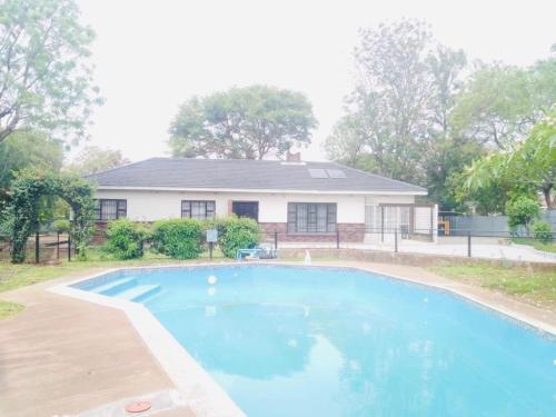 una piscina frente a una casa en Mpande - The Roots Your Home Away from Home, en Bulawayo
