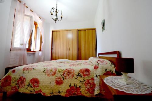 a bedroom with a bed with a flowered blanket at B&B Resort Tina in Gesualdo