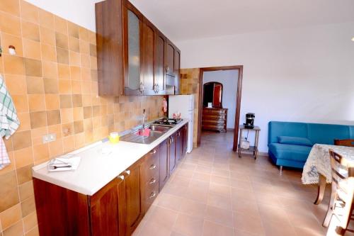 a kitchen with wooden cabinets and a blue couch at B&B Resort Tina in Gesualdo