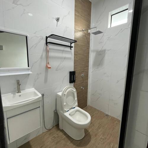 a white bathroom with a toilet and a sink at CasaD'Tamarind Homestay with Private Pool in Alor Setar