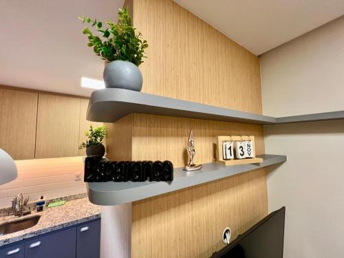 a kitchen with a counter with a clock and plants at Bahamas 357 - Com Garagem in Águas Claras