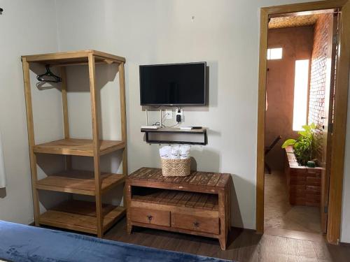 ein Wohnzimmer mit einem TV und einem Regal mit einem TV in der Unterkunft Recanto do Calango in Lajeado