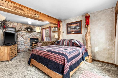德卢斯The Inn On Gitche Gumee - The Wolves Den的一间带床和石墙的卧室