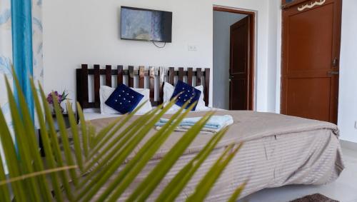 a bedroom with a bed with blue and white pillows at Summer Guest House in Chauntrā