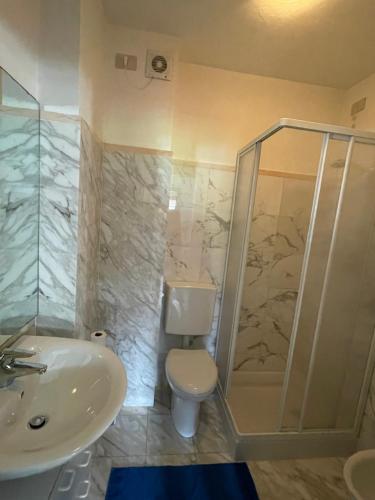 a bathroom with a shower and a toilet and a sink at Oberthaler Hotel in Sappada