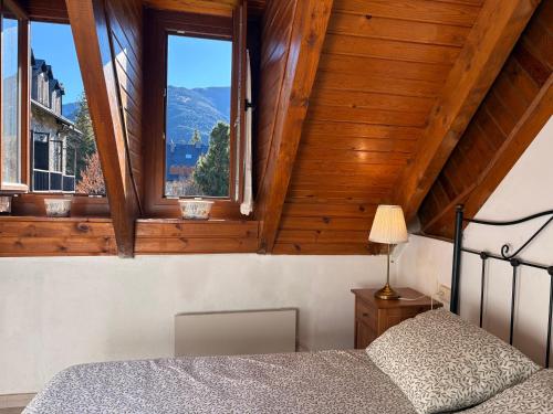 een slaapkamer met een bed en twee ramen bij Chimenea y piscina-Dúplex perfecto para todo el año - Herbasabina 4 in Pla de l'Ermita